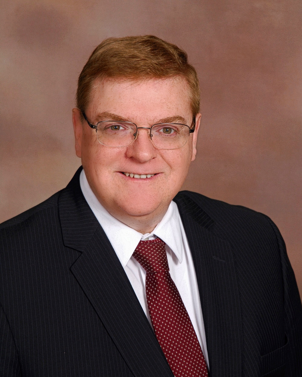 Picture of Reverend Russell Logston with red tie and black suit coat